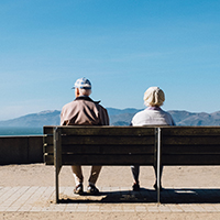 zwei ältere Menschen auf einer Bank sitzend